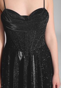 Czarna wieczorowa sukienka z dopasowanym gorsetem, cienkimi ramiączkami, teksturowanym, błyszczącym wykończeniem oraz rozkloszowanym dołem z delikatnymi plisami.