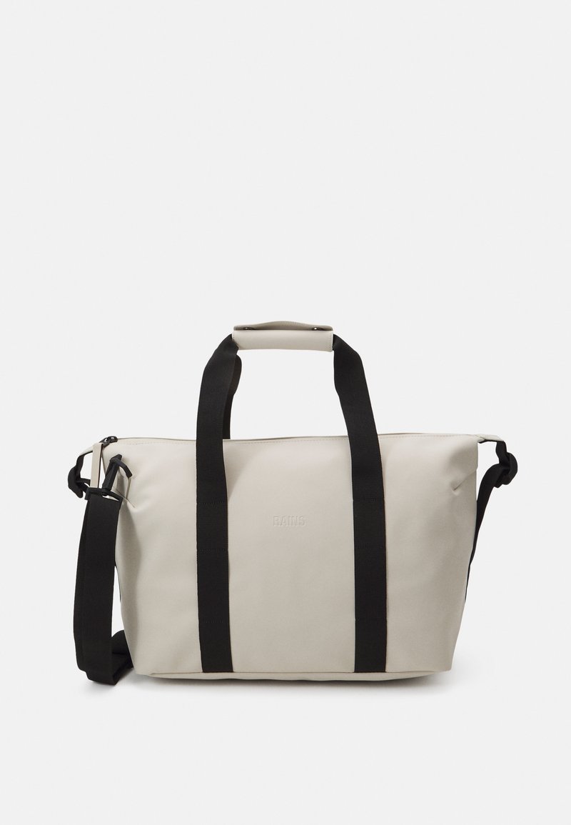 Lys grå duffelbag med sorte stropper, som har et slankt design, holdbart materiale og et diskret præget logo. Justerbar skulderrem er inkluderet.