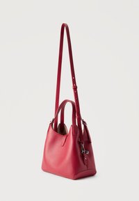 Κόκκινη δερμάτινη τσάντα με μακριά ρυθμιζόμενη λουρί ώμου, κοντά χερούλια και ασημένια λεπτομέρεια φερμουάρ σε απλό φόντο.