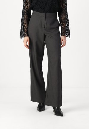 Gray wide-leg trousers with a smooth texture and a tailored fit, paired with a black lace top featuring intricate patterns.