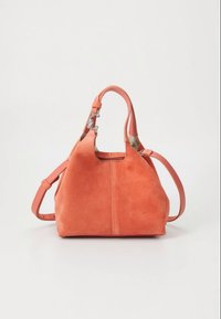Coral suede handbag with short handles, adjustable shoulder strap, and silver hardware clasp on a white background.