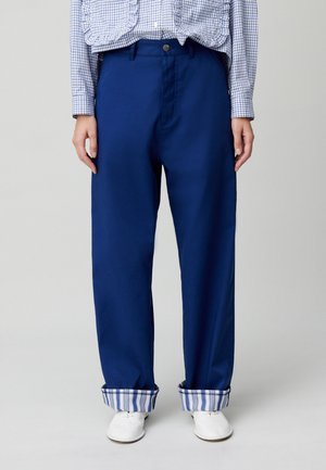 Pantalones de pierna ancha de color azul marino, con una textura suave y un detalle de puño a rayas. Con cierre de botón y un corte relajado.
