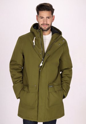 Parka verde oliva, tessuto impermeabile, chiusura frontale con zip e bottoni a pressione, cappuccio con cordino, due tasche frontali, fodera nera e vestibilità attillata.