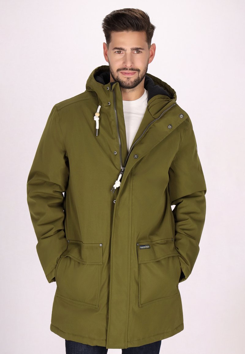 Parka verde oliva, tessuto impermeabile, chiusura frontale con zip e bottoni a pressione, cappuccio con cordino, due tasche frontali, fodera nera e vestibilità attillata.