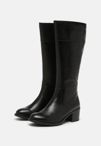 Bottes noires montant jusqu'aux genoux en cuir lisse, dotées d'un bout arrondi et d'un talon bloc. Design minimaliste sans quincaillerie ni motifs visibles.