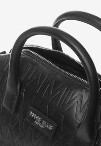 Borsa a mano in pelle nera con motivo in rilievo del logo, doppie maniglie arrotondate e dettagli in metallo argentato lungo l'apertura superiore.