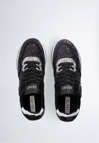 Svarta sneakers med glittrig ovandel, silverdetaljer på snörena och texturerade material; vit sula med svarta detaljer.