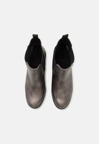 Botas de tobillo de cuero negro con paneles laterales elásticos, punta redondeada y textura suave, con un diseño minimalista.
