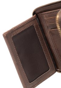Intérieur d'un portefeuille en cuir marron avec une poche en textile dense, des fentes pour cartes et des bords soigneusement cousus ; fermeture éclair en haut.