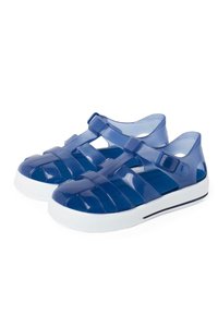 Navy blue, translucent plastic sandals with a strappy design, adjustable buckle, and white sole featuring a textured pattern.