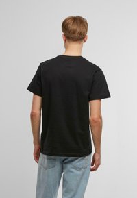 Sort bomulds T-shirt med rund hals og korte ærmer, der har en glat tekstur og et simpelt, uprydet design.
