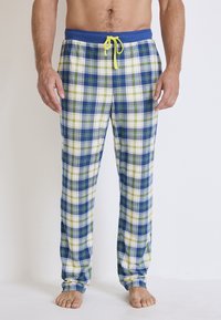 Katoenen plaid pyjamabroek met blauw, groen en witte ruitpatronen, een elastische tailleband met blauwe band en gele koord.