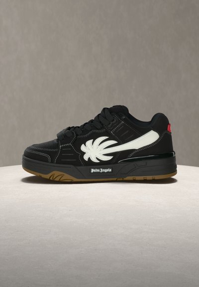 Schwarzer Sneaker in niedriger Ausführung mit weißem Palmenblatt-Logo, schwarzen Schnürsenkeln, gummierter Sohle und "Palm Angels"-Markenaufdruck auf der Zwischensohle.