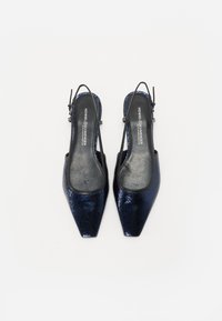 Escarpins slingbacks bleu marine avec une finition en vernis texturé, à bouts pointus et avec des brides ajustables. Intérieur lisse avec étiquette de marque.