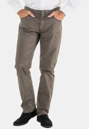 Pantaloni in misto cotone grigi con vestibilità slim, dotati di cinque tasche, dettagli cuciti e chiusura con bottone in vita. Indossati con scarpe nere.