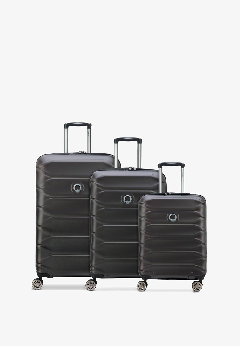 Set di valigie rigide nere di tre dimensioni, con superficie testurizzata, manici telescopici e quattro ruote girevoli per una maggiore mobilità.