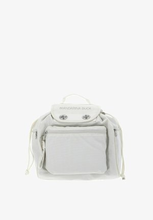 Sac à dos en tissu blanc à forme arrondie, équipé d'une poignée supérieure, d'une poche avant zippée et d'accents métalliques argentés. Logo sur le rabat.