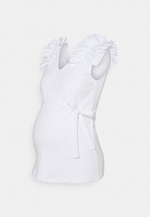 Vit mammatopp med volangdetaljer på axlarna, V-ringning och knytning i midjan, tillverkad i mjukt tyg, figurnära design som framhäver magen.