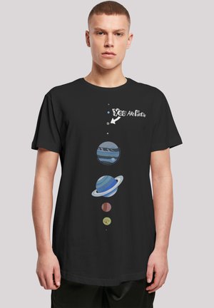 Black t-shirt with a graphic design featuring planets in a vertical arrangement and text "You Are Here" with an arrow pointing at Earth.