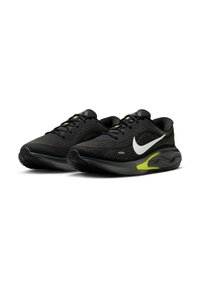 Czarne buty sportowe z siateczkową cholewką, białym logo Nike, żółtymi akcentami, amortyzowaną podeszwą i teksturowaną czarną podeszwą zewnętrzną dla lepszej przyczepności.
