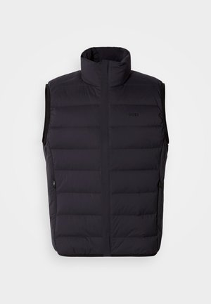 Zwart puffervest met hoge kraag, ritszakken en subtiele branding. Heeft een doorgestikt ontwerp en een gladde, lichte textuur.