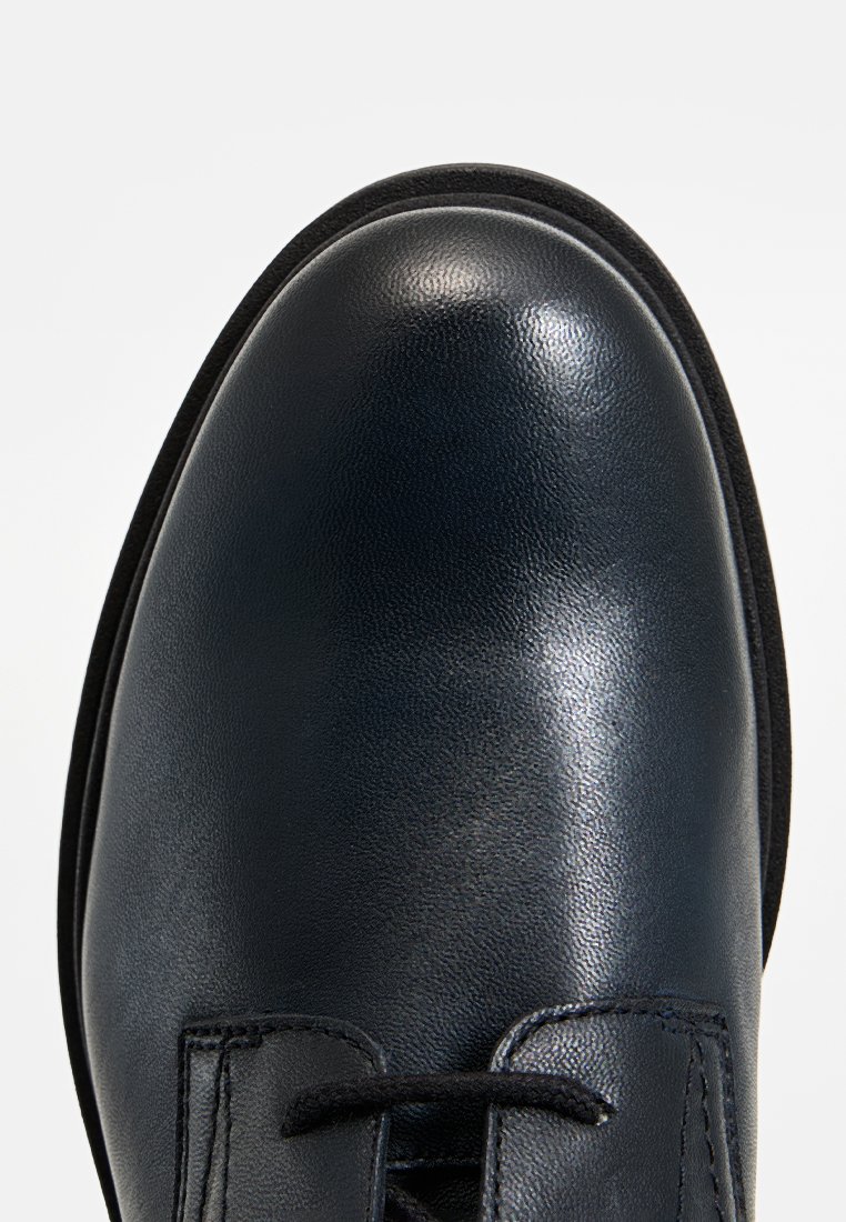 Zwarte leren schoen met een gladde afwerking en een ronde neus. Beschikt over een vetersluiting en minimale stiksels op het bovenwerk. De zool is lichtvoudig textuur.