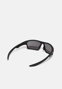 Schwarze Sonnenbrille mit dunklen Gläsern, die ein schlankes geometrisches Design und flexible Kunststoffrahmen mit matter Oberflächenbeschaffenheit hat.