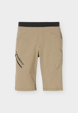 Μπεζ αθλητικό σορτς μήκους μέχρι το γόνατο με μαύρη ελαστική μέση, πλαϊνή τσέπη με φερμουάρ και λογότυπο "DYNAFIT" στο αριστερό πόδι.