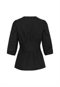 Blouse noire à manches longues avec taille cintrée et détail de tissu froncé dans le dos, dotée d'un col rond et d'un ourlet légèrement évasé.