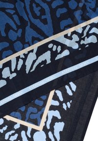 Modrý šátek s kombinací abstraktních leopardích vzorů v tmavě modré, světle modré a krémové barvě, s dekorativním štítkem "VEČNÁ NEBE".