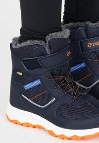 Navy-wasserfeste Stiefel mit grauem Futter, orangen Akzenten und Netzstruktur. Verfügt über ein sicheres Schnürsystem und eine langlebige Gummisohle.