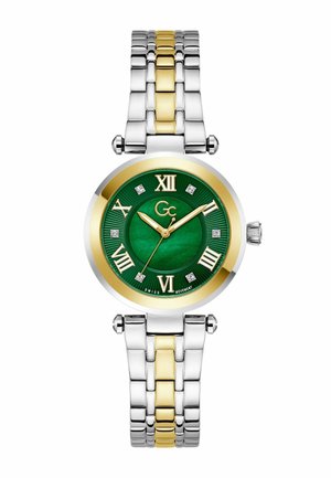 Kerek karóra zöld számlappal, arany római számokkal, gyémánt jelzőkkel és kétszínű ezüst-arany fémszíjjal.