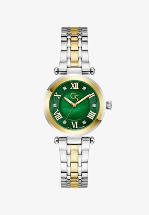 Ringikujuline käekell rohelise sihverplaadiga, kuldsed rooma numbrid, teemandid näitamiseks ning kahes toonis hõbe- ja kullavärviline metallist käevõru.