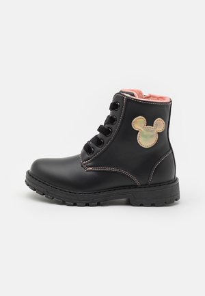 Botte noire pour enfant à lacets avec doublure intérieure rose et un patch doré en forme de Mickey Mouse sur le côté.