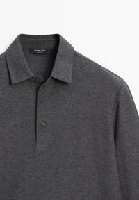 Donkergrijs poloshirt van textuurstof. Voorzien van een klassieke kraag en drie bruine knopen. Merketiket zichtbaar aan de binnenkant van de nek.