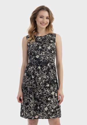 Robe noire sans manches avec un motif floral blanc, corsage ajusté, jupe évasée ; tissu lisse, longueur mi-cuisse, encolure ronde, détails minimalistes.