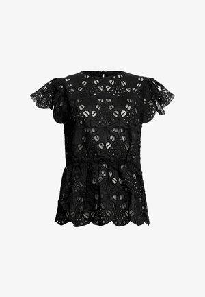 Mustat pitsimekot, joissa on lyhyet röyhelöhihoja, aaltoileva helma ja monimutkaisia leikattuja kuvioita. Kankaan pinta on tekstuuri.