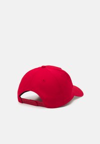 Rød baseballkasket med et ensfarvet stofdesign, buet skygge, justerbar plastikrem bagpå og ventilationshuller.