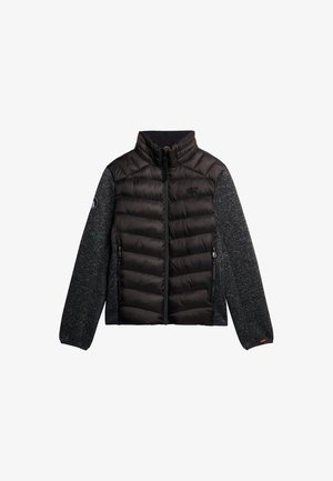 Polstret sort bomberjakke med grå ærmer. Har en høj krave, lynlås foran, sidelommer og logo på venstre ærme.