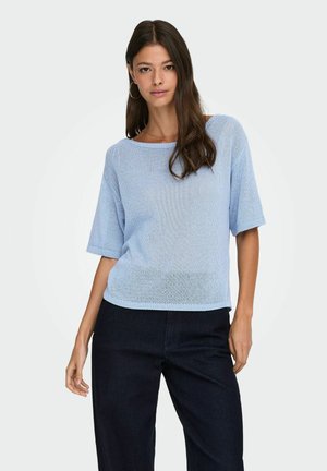 Lichtblauw gebreid shirt met korte mouwen, een ronde halslijn en een losse pasvorm, met een geribbelde rand en textiel. Gecombineerd met donkere broek.