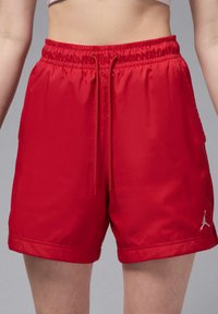 Rote sportliche Shorts aus glattem Stoff, ausgestattet mit einem elastischen Bund mit Kordelzug und einem kleinen Logo an der unteren Seite.