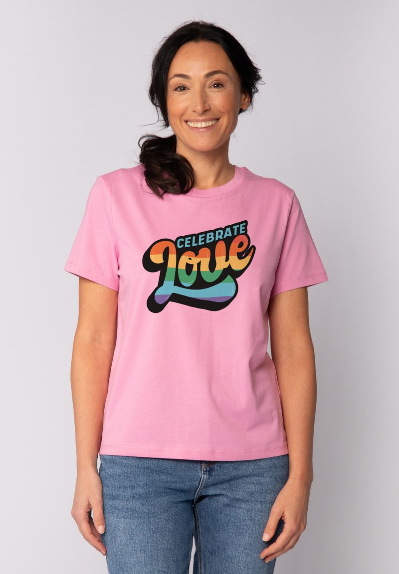 Roze katoenen t-shirt met een kleurraf grafiek en de tekst "Vier de Liefde" in vette, speelse typografie. Korte mouwen en een ronde hals.