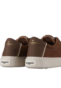 Sneaker basse marroni con suole bianche, marchio dorato "Alexander London" sulle etichette del tallone e loghi neri "Alexander London" sui tappi del tallone.
