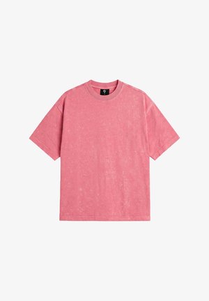Różowy t-shirt z krótkim rękawem, okrągłym dekoltem i subtelnym teksturowanym wzorem, przedstawiony na białym tle.