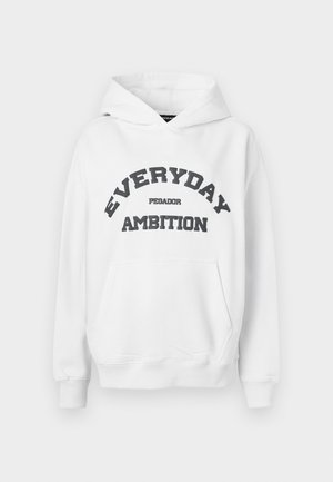 Bijela dukserica s kapuljačom, koja ima prednji džep i podebljani crni natpis "SVAKODNEVNA AMBICIJA" i "PEGADOR" u obliku luka.