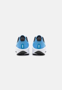 Blue and black athletic shoes with a textured mesh upper, featuring a white midsole and rubber outsole. Rear view shows a contrasting accent.