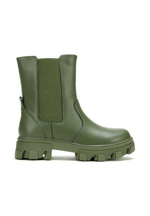 Botte en cuir vert olive mi-mollet avec semelle épaisse à crampons, panneau latéral élastique et languette de traction à l'arrière.