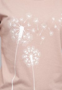 Lys rosa bomulls t-skjorte med hvite dandeliontrykk og sømløse frø, som viser en jevn tekstur og rund hals.