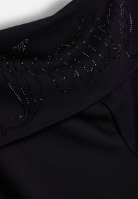 Tessuto nero con una texture liscia caratterizzato da un motivo decorativo di luccicanti strass neri in un design fluente vicino al colletto.