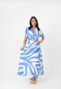 Langes blaues und weißes Kleid mit abstrakten Wellenmustern, kurzen Ärmeln, einem V-Ausschnitt und einer taillierten Taille. Der Stoff wirkt leicht und glatt.